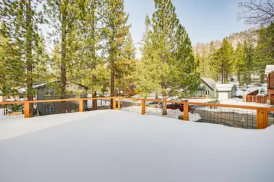 a snow covered deck with a fence and trees at 11 Mi to Ski Resorts! Lake Tahoe Gem with Pool Table in South Lake Tahoe