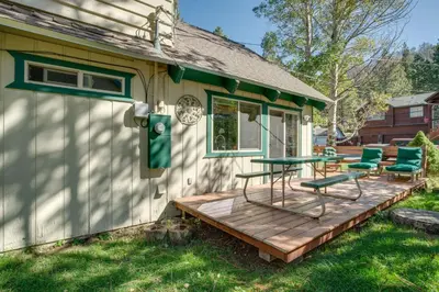 a deck on the side of a house with green chairs at 11 Mi to Ski Resorts! Lake Tahoe Gem with Pool Table in South Lake Tahoe