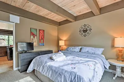 a bedroom with a large bed and a tv at 1 Mi to Shore Quiet South Lake Tahoe Condo in South Lake Tahoe