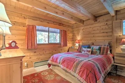 a bedroom with a bed in a log cabin at 2 Mi to Northstar Resort Idyllic Cabin with Shuttle in Truckee