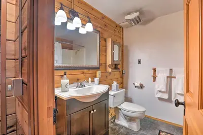 a bathroom with a sink and a toilet and a mirror at 2 Mi to Northstar Resort Idyllic Cabin with Shuttle in Truckee