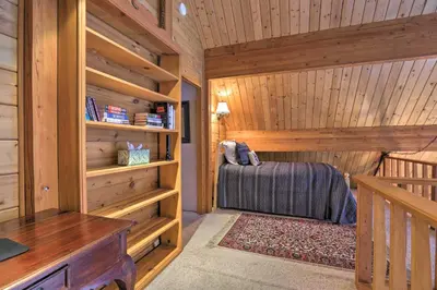 a bedroom with a bed in a log cabin at 2 Mi to Northstar Resort Idyllic Cabin with Shuttle in Truckee