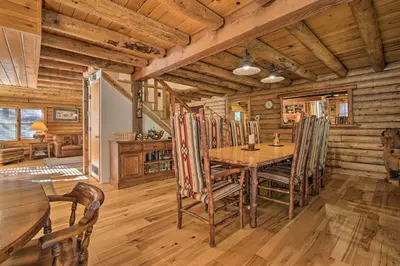 a dining room in a log cabin with a table and chairs at 5 Mi to Hiking Custom Cabin with Deck in Arnold! in Arnold