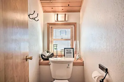 a small bathroom with a toilet and a window at 5 Mi to Hiking Custom Cabin with Deck in Arnold! in Arnold