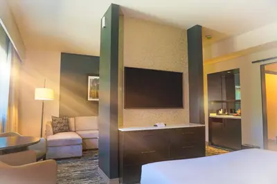 a hotel room with a bed and a flat screen tv at The Hotel at Black Oak Casino Resort in Tuolumne