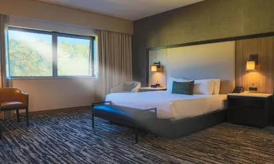 a hotel room with a large bed and a window at The Hotel at Black Oak Casino Resort in Tuolumne
