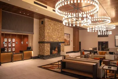 a lobby with a fireplace and chandeliers at The Hotel at Black Oak Casino Resort in Tuolumne