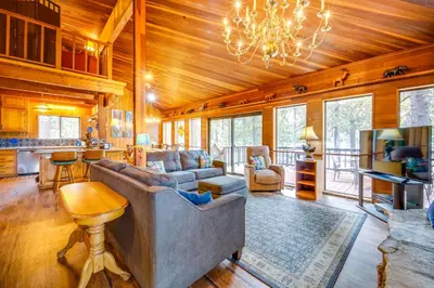 a living room with a couch and a chandelier at Waterfront Truckee Cabin on Donner Lake! in Truckee