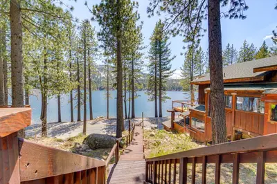 a house on a lake with a wooden deck at Waterfront Truckee Cabin on Donner Lake! in Truckee