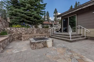 a patio with a bench and a stone wall at Chamonix # 62 in Mammoth Lakes
