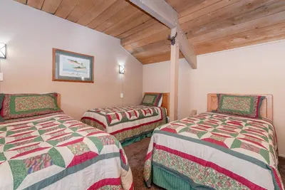two twin beds in a room with wooden ceilings at Bigwood W #90 in Mammoth Lakes