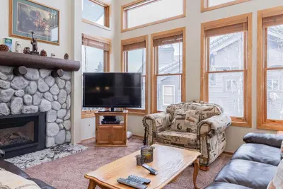 a living room with a fireplace and a flat screen tv at Snowcreek #856 Phase V in Mammoth Lakes