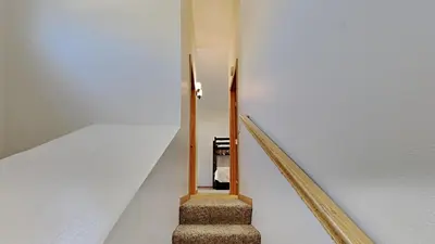 a staircase in a house with a white wall at Spectacular 3 Bedroom Townhome with Pool in Mammoth Lakes