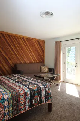 a bedroom with a bed and a table and a window at Kern Riverview Inn in Kernville