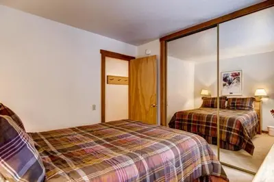 a bedroom with two beds and a mirror at Ski-InandSki-Out Northstar Condo Near Lake Tahoe! in Truckee