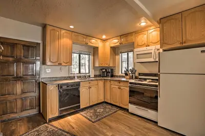 a kitchen with wooden cabinets and a white refrigerator at Lakefront Cabin with Beach Access 8 Mi to Northstar in Tahoe Vista