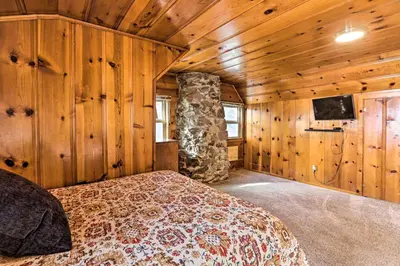 a bedroom with a bed in a room with wooden walls at Lakefront Cabin with Beach Access 8 Mi to Northstar in Tahoe Vista