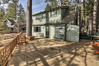 a green house with a deck and a fence at Lakefront Cabin with Beach Access 8 Mi to Northstar in Tahoe Vista