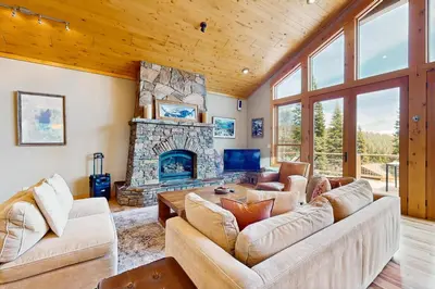a living room with couches and a stone fireplace at Extraordinary Tahoe-Donner Modern Mountain Home in Truckee