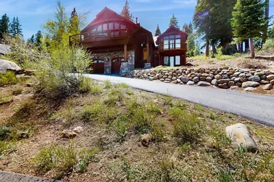 a house on a hill with a road in front of it at Extraordinary Tahoe-Donner Modern Mountain Home in Truckee