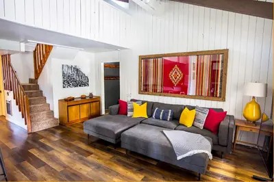 a living room with a gray couch with colorful pillows at The Mammoth House in Mammoth Lakes