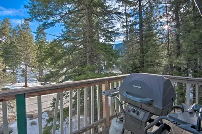 a motor cycle parked on a wooden deck with trees at Stateline Ski House Walk to Boulder Lift! in Stateline