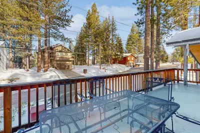 a glass table on a deck with snow on the ground at Skyline Serenity in South Lake Tahoe