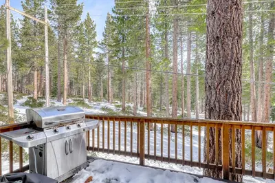 a grill on a deck next to a tree at Skyline Serenity in South Lake Tahoe