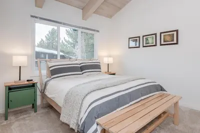 a bedroom with a bed with a bench and a window at Chateau Blanc 11 in Mammoth Lakes