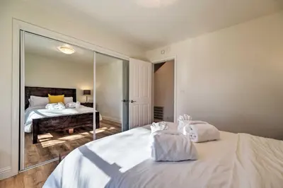 a bedroom with a large white bed and a mirror at Hot Tub and Mtn Views Peaceful Columbia Retreat! in Columbia