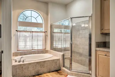 a bathroom with a tub and a glass shower at Hot Tub and Mtn Views Peaceful Columbia Retreat! in Columbia