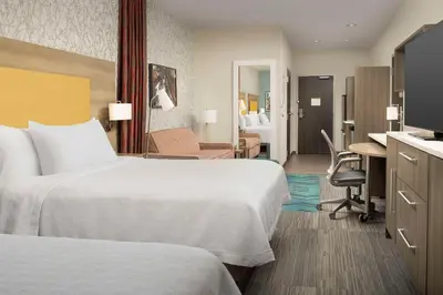 a hotel room with two beds and a desk at Home2 Suites By Hilton Clovis Fresno Airport in Clovis