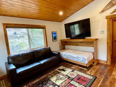 a living room with a leather couch and a flat screen tv at Pioneer in Oakhurst