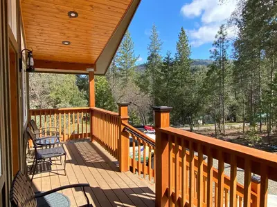 a large wooden deck with chairs on it at Pioneer in Oakhurst