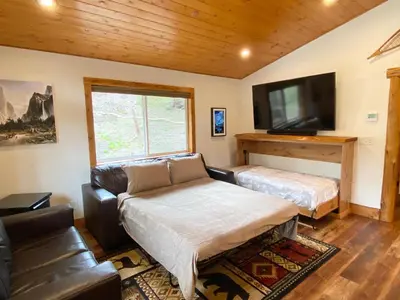 a living room with a couch and a flat screen tv at Pioneer in Oakhurst