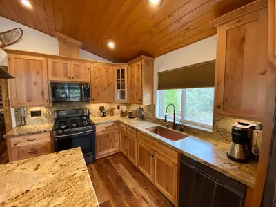 a kitchen with wooden cabinets and a sink and a stove at Pioneer in Oakhurst