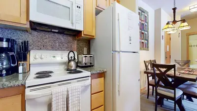 a kitchen with a stove and a white refrigerator at Sunstone #322 condo in Mammoth Lakes