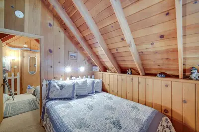 a bedroom with a bed in a room with wooden walls at Mountain Tops Ponderosa Getaway Near Dome Rock! in Ponderosa