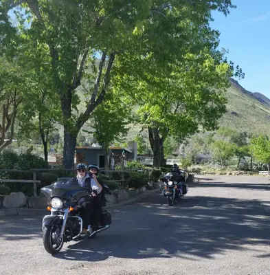 two people riding motorcycles down a street at Toiyabe Motel in Walker