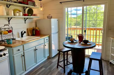 a kitchen with a table and a refrigerator at Amazing Loft on Horse Ranch in Pilot Hill