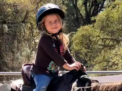 a little girl wearing a helmet sitting on a horse at Amazing Loft on Horse Ranch in Pilot Hill