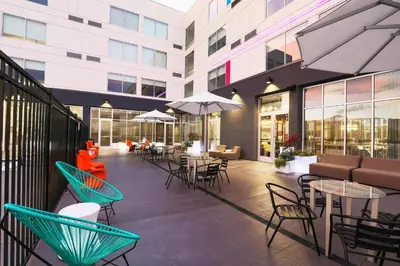 an outdoor patio with tables and chairs and umbrellas at Aloft Reno Tahoe International Airport in Reno