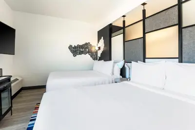 a hotel room with two beds and a tv at Aloft Reno Tahoe International Airport in Reno