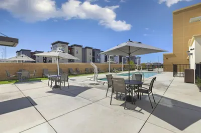 a patio with tables and chairs with umbrellas and a pool at Fairfield Inn & Suites by Marriott Lodi in Lodi