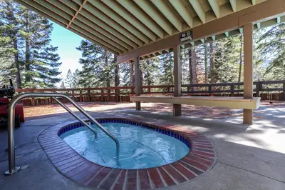 a hot tub on a patio with a bench at Hidden Valley #107 condo in Mammoth Lakes