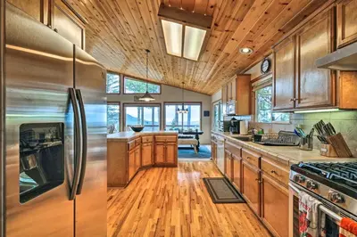 a kitchen with wooden cabinets and stainless steel appliances at Near Hiking Home with Deck in Twain Harte! in Twain Harte