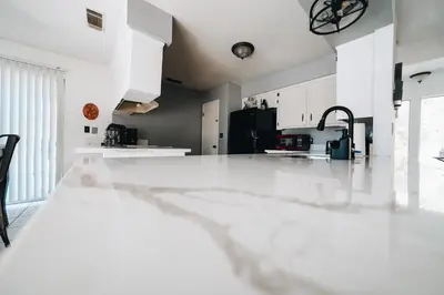 a kitchen with white cabinets and a black refrigerator at Pebble Creek in Three Rivers