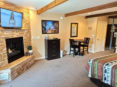 a bedroom with a fireplace and a table in a room at Lakeland Village #110 in South Lake Tahoe