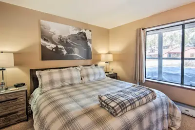 a bedroom with a bed and a large window at Walk to Ski Lift and Village Lovely Kirkwood Condo! in Kirkwood