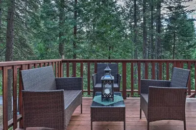 a patio with chairs and a table with a lantern at 4 Mi to Big Tree State Park Serene Cabin with Deck in Arnold